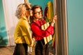 beautiful retro styled businesswomen in colorful blouses with folders looking at window