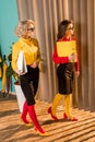 beautiful retro styled businesswomen in colorful blouses walking with folders