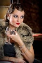 Beautiful retro woman with glass. Vintage makeup and wavy hairstyle. Hollywood style of the 20s Royalty Free Stock Photo