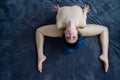 Beautiful rhythmic gymnast with blue hair in a curved pose. top view Flexible woman in beige biflex jumpsuit in a curved