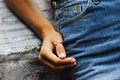 A beautiful ring on the finger of a young girl dressed in denim jeans and sitting on a stone wall