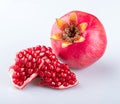 A beautiful ripe whole pomegranate with a beautiful crown and two pieces of delicious young ripe pomegranate, with a shadow