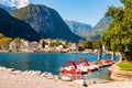 Beautiful Riva del Garda cityscape with vibrant red pedal boats parked in a row on the beach and city surrounded by high dolomite Royalty Free Stock Photo
