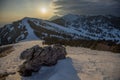 Beautiful rock formation on the top of Soriska Planina ski slope, viewed towards setting sun over majestic mountains in Slovenia