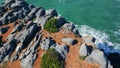 Beautiful rocky shoreline stormy ocean sunny day. Drone waves rolling coast. Royalty Free Stock Photo