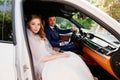 A beautiful and romantic bride and the groom sit in cars. Rent transport