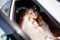 A beautiful and romantic bride sits in cars. Rent transport for the wedding.