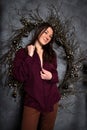 Beautiful romantic brunette woman in pajamas in cozy loft style room with garlands and rustic wreath. Portrait authentic