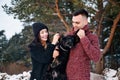 Beautiful romantic couple is having fun with their dog outdoors in winter day Royalty Free Stock Photo