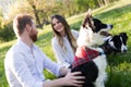 Romantic couple in love walking dogs in nature and smiling Royalty Free Stock Photo