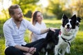 Romantic couple in love walking dogs in nature and smiling Royalty Free Stock Photo