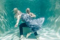 Beautiful romantic couple of lovers hugging gently under water