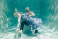 Beautiful romantic couple of lovers hugging gently under water