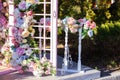 Beautiful romantic festive place made with wooden arch and flowers decorations for outside wedding ceremony in summer garden. Gaze