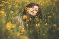 Beautiful romantic girl on blooming rapeseed field enjoying nature, young elegant woman walking, calm female face, concept Royalty Free Stock Photo