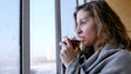 Beautiful romantic girl with a cup of tea near the winter window. Winter day, cozy mood. Royalty Free Stock Photo