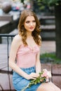 Beautiful romantic girl in a pink top and denim skirt holding a bouquet of roses Royalty Free Stock Photo