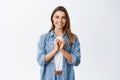 Beautiful romantic girl showing heart gesture, I love you sign, smiling happy at camera, standing against white Royalty Free Stock Photo