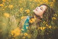 Beautiful romantic girl sitting on blooming rapeseed field enjoying nature, young elegant woman walking, pretty female face Royalty Free Stock Photo