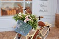 Beautiful Romantic Landscape: Vintage Wicker Basket With Flowers Near The Cafe. Old Bicycle With Flowers In A Metal Basket On The
