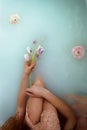 Beautiful romantic red-haired girl sitting in the bath and holding flowers . The face is not visible. In lace dress Royalty Free Stock Photo