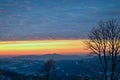 Beautiful romantic winter sunset. Silhouette of the mountains Jested in the background and tree in the foreground.