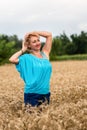 Beautiful romantic woman in white shirt and jeans stand in the golden wheat field. Happy summer concept Royalty Free Stock Photo