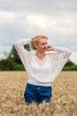 Beautiful romantic woman in white shirt and jeans stand in the golden wheat field. Happy summer or concept Royalty Free Stock Photo