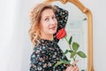 Beautiful romantic young blonde woman in dress with red rose near mirror Royalty Free Stock Photo