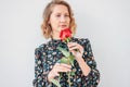 Beautiful romantic young blonde woman in dress with red rose on white background isolated Royalty Free Stock Photo