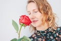 Beautiful romantic young blonde woman in dress with red rose on white background isolated Royalty Free Stock Photo