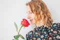 Beautiful romantic young blonde woman in dress with red rose on white background isolated Royalty Free Stock Photo