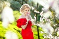 Beautiful romantic young woman in a wreath of flowers posing on a background of flowers. Inspiration of spring and Royalty Free Stock Photo