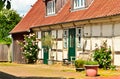 Beautiful and romantical entrance and garden of an old german farmhouse with framework and blooming plants