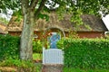 Beautiful and romantical entrance and garden of an old german farmhouse with framework and blooming plants