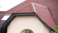 Beautiful roof of a city house with red roofing tiles on cloudy sky background. Stock fotage. Facade of new residential Royalty Free Stock Photo