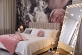 Room interior with large bed, mirror and floral pattern on wall Royalty Free Stock Photo