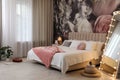 Room interior with large bed, mirror and floral pattern on wall Royalty Free Stock Photo