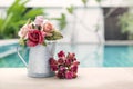 Beautiful rose paper flower in water tin pot over blurred swimming pool background Royalty Free Stock Photo