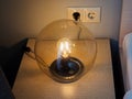A beautiful round lamp shines near bedside table Royalty Free Stock Photo