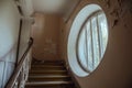 A beautiful round window in an old abandoned hospital. Ancient staircase. The interior of an abandoned building. Royalty Free Stock Photo