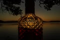 beautiful rum bottle full with rum holding in front of a sunset over Watson Taylors Lake at Crowdy Bay National Park, New South Royalty Free Stock Photo