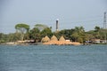 A beautiful rural area on the bank of a river. River and village area scenery with blue sky. Boats on the river and huge haystacks