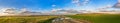 Rural autumn landscape panorama with road, field and blue sky