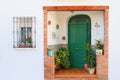 Beautiful rural door entrance with green doors and flowers