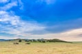 Beautiful rural landscape with a big blue sky over the hills and cropper and plowing vehicles