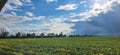 Beautiful rural landscape of green agricultural fields under blue sky with big fluffy white clouds Royalty Free Stock Photo