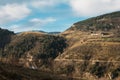 Beautiful rural landscape of mountainous area, few farm houses, blue sky with white clouds on sunny day in winter Royalty Free Stock Photo