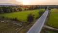 Beautiful rural landscape with road, buildings, orange sky with sundown