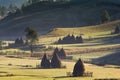 Beautiful rural mountain landscape in the morning light with fog, old houses and haystacks Royalty Free Stock Photo